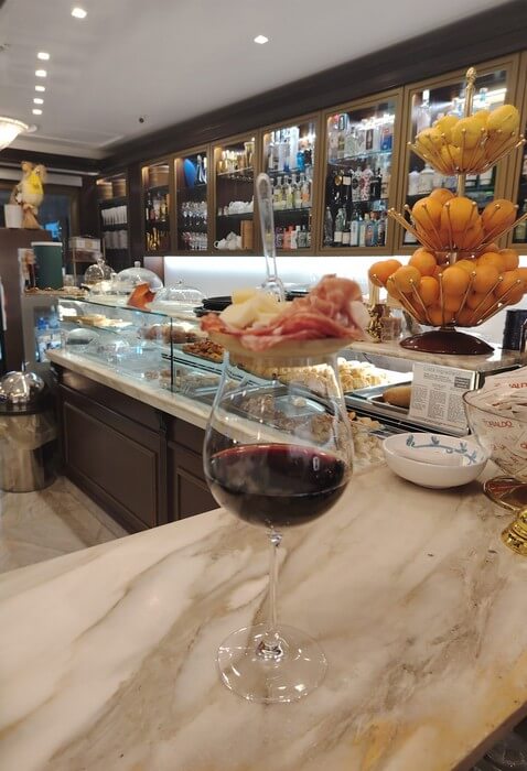 Calice di vino rosso (lacrima cristhy) con piccolo tagliere di salumi